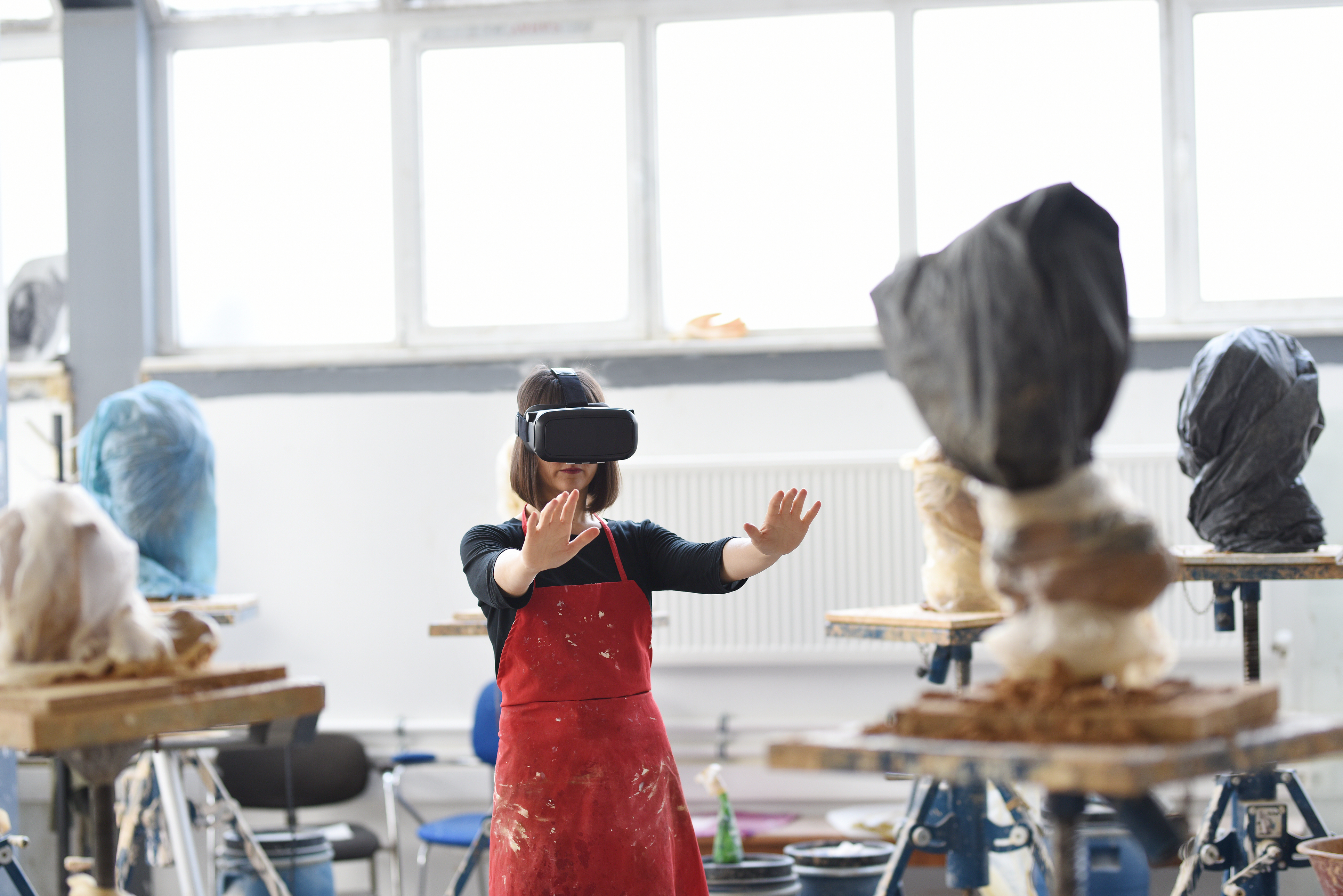 AI artist using virtual reality technology in a creative studio, blending digital tools with artistic practice.