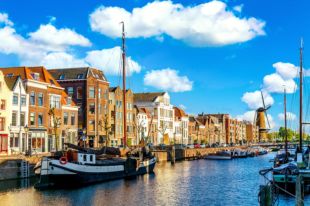 Old historic district Delfshaven with wildmill and houseboats in Rotterdam, South Holland, The Netherlands. Summer sunny day